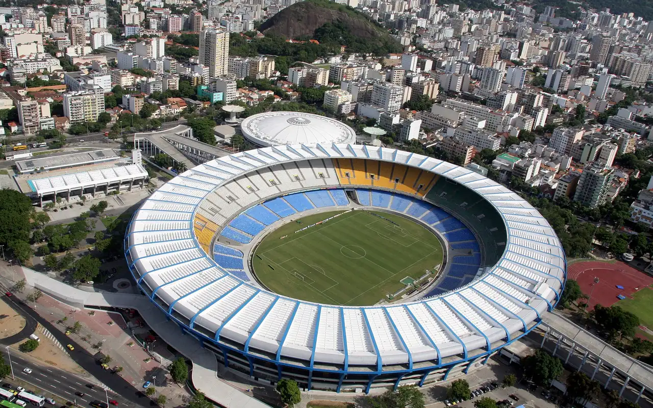 Aerial view of the Maracanã: apartment blocks and narrow streets run up to the stadium perimeter on every side, with no circulation ring separating it from the neighborhood.